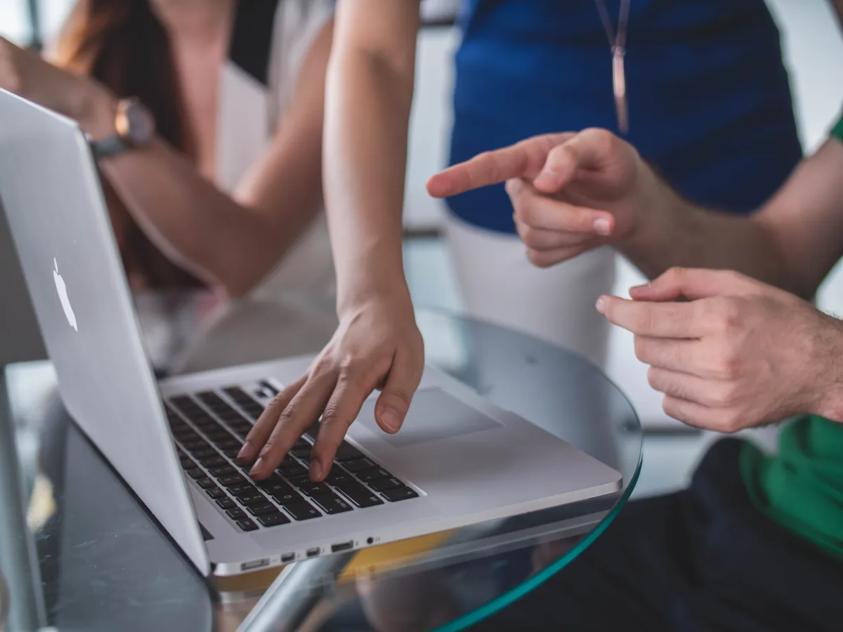 person touching and pointing macbook pro